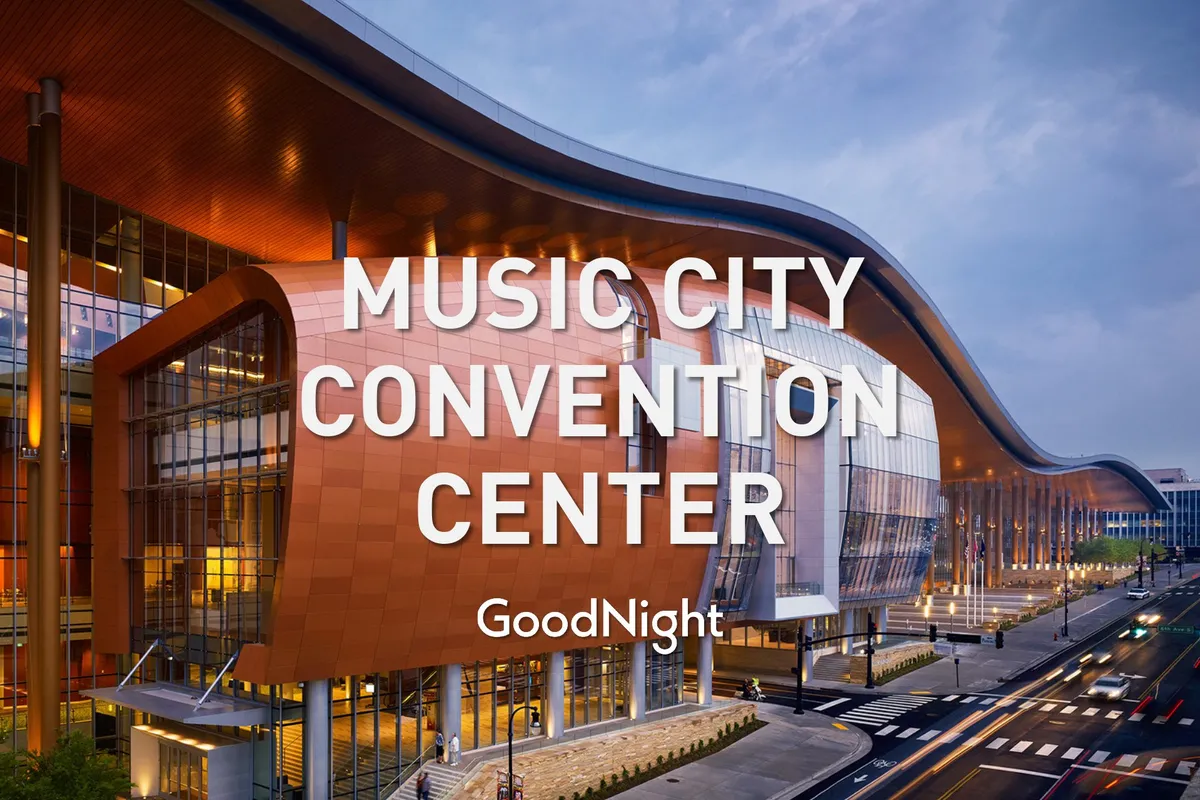 An exterior shot of the Music City Center with its distinctive curved roof and illuminated signage, signaling a hub for conferences, exhibitions, and major corporate events in Nashville.