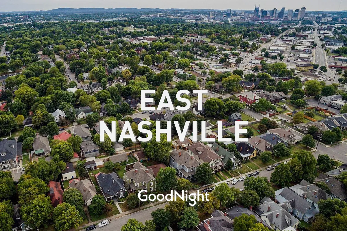 A panoramic exterior shot showing residential neighborhoods, abundant greenery, and the Nashville skyline in the background. The image conveys a sense of community, walkability, and proximity to urban attractions.