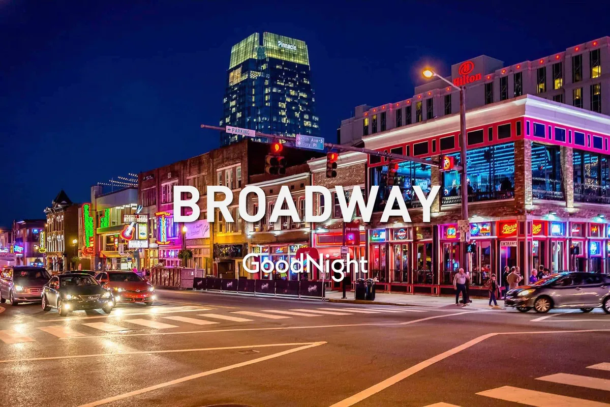 A lively nighttime scene featuring neon lights, a bustling street filled with people, and the high-rises of downtown Nashville. The energy of nightlife is on full display, with groups dining, enjoying live music, and exploring the city after dark.