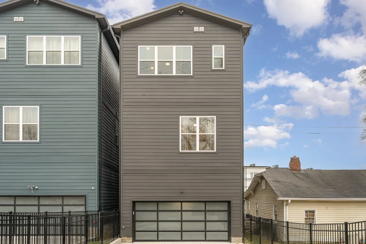 This exterior image highlights the modern architecture of the property, prominently featuring the garage door and large windows. The garage is clearly visible, suggesting easy parking access and a welcoming, contemporary entryway.